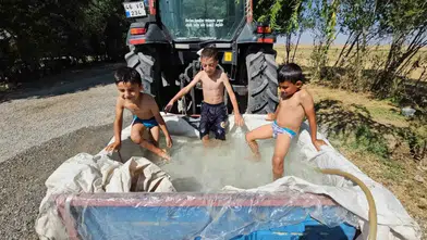 Bitlis’te traktör sepetini suyla dolduran çocuklar serinledi