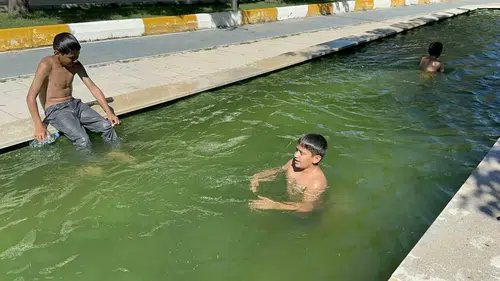 Elazığda çocuklar serinlemek için zabıtayı atlatıp süs havuzuna giriyor