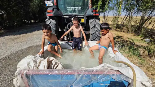 Bitlisli çocuklar traktör arkasına kurdukları seyyar havuzla serinledi