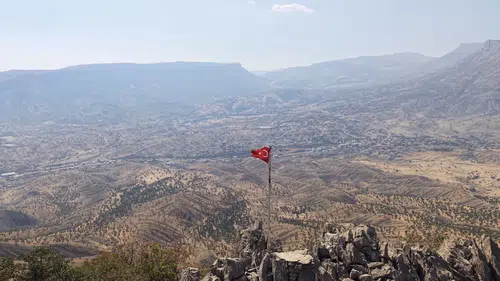 Hakkari'de gazeteci 2 bin rakımlı tepedeki yıpranmış bayrağı yeniledi