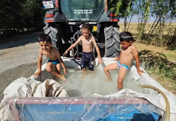 Bitlis’te traktör sepetini suyla dolduran çocuklar serinledi